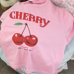 A Womens croped pink cherry print shirt .